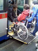自動ステップを利用して車椅子でバスに乗車中の写真